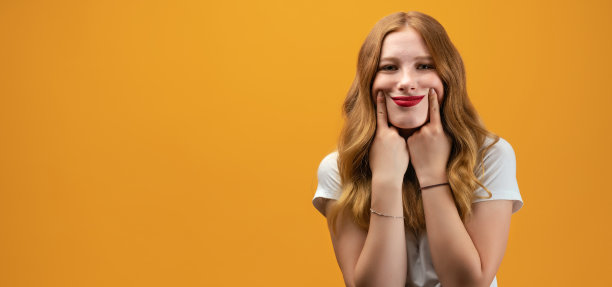 年轻女子假装微笑，她的嘴伸展成一个微笑，强迫自己高兴。假笑的概念图片下载