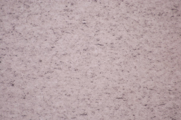 苍白的玫瑰石英点缀着黑色平坦抛光表面特写。图片下载