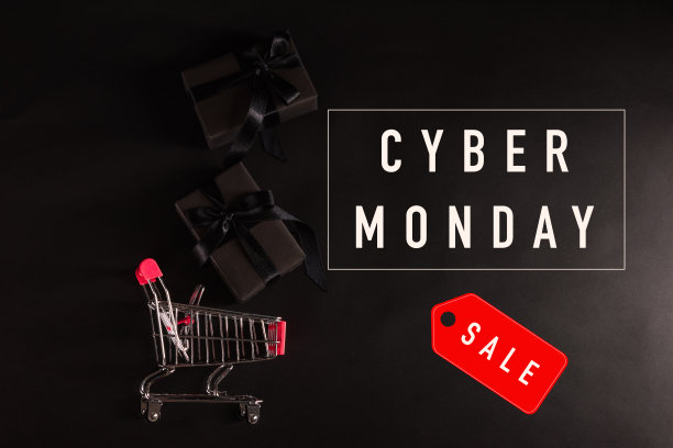 用黑色纸包好的礼盒和黑色蝴蝶结丝带的礼物落在购物车里图片下载