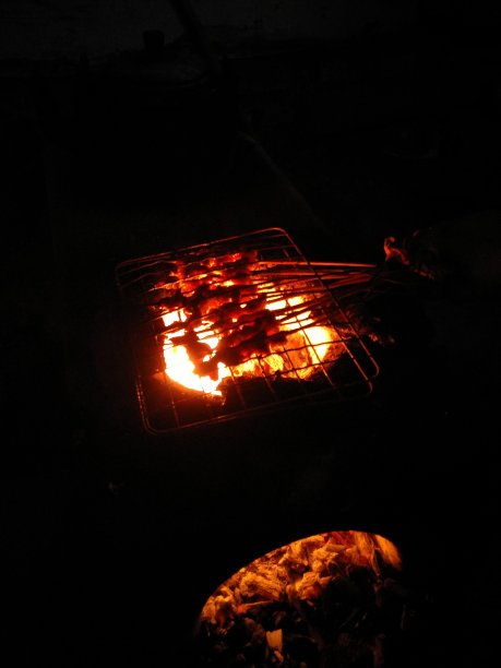 在传统的石制柴火炉上烧烤沙茶图片下载