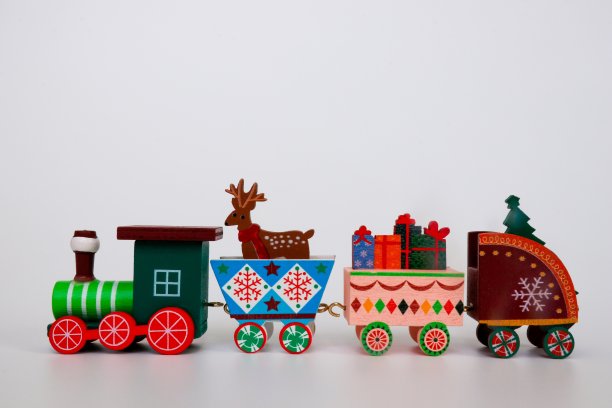 一辆木制的圣诞玩具火车在白色的背景上承载着寒假的特色。装饰圣诞节的概念图像。可供复制的空闲空间。图片下载