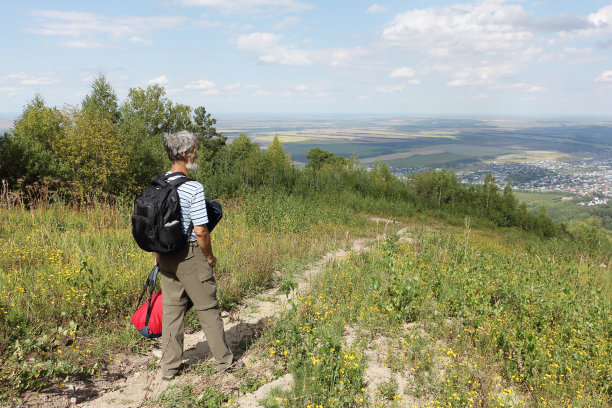 一名背着背包的男子从俄罗斯阿尔泰别洛库里哈市的捷尔科夫卡山上下山图片下载