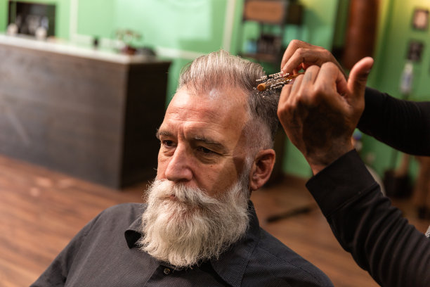 非裔美国理发师戴口罩，用梳子梳理白胡须的白人男性冠状病毒疫情预防图片下载