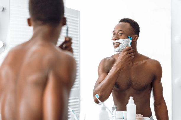 赤膊非裔美国人在浴室用剃刀刮脸图片下载