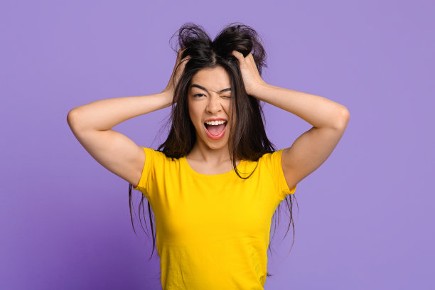 疯狂的情绪。疯狂的亚洲女人摸着凌乱的头发，对着镜头眨眼图片下载