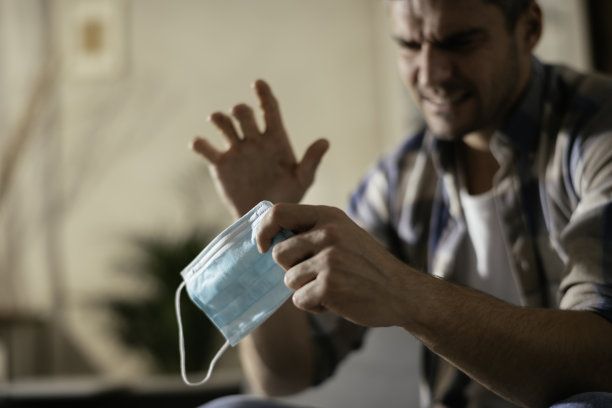 一个焦虑的男人在压力与保护面具库存照片图片下载