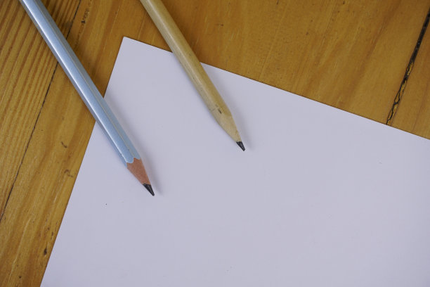 白纸和铅笔放在木桌上。复古复制空间背景概念图片下载