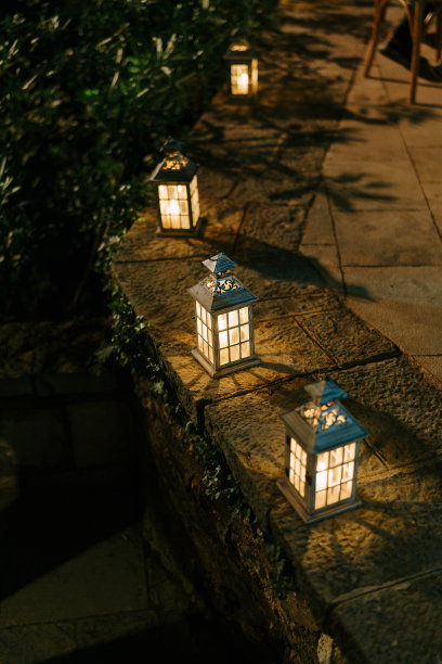 石头篱笆上的烛台在夜晚点亮。图片下载