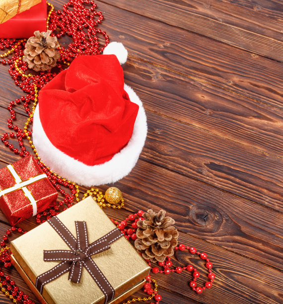 有珠子的礼盒，玩具和圣诞老人的帽子放在复古的木头桌子上图片下载