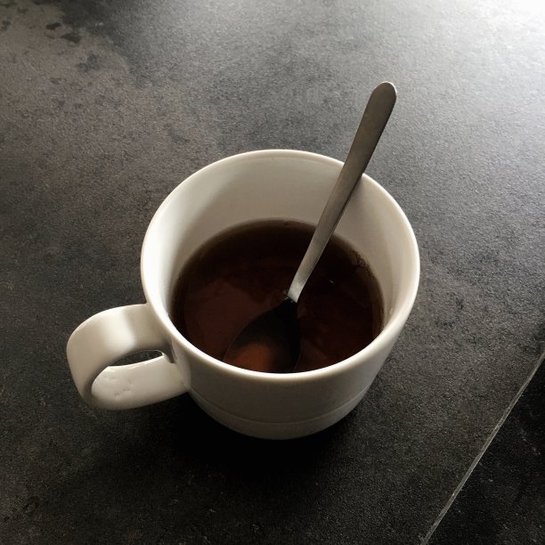 一杯用金属勺的茶图片下载