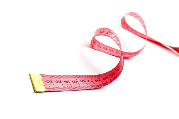 红色的卷尺卷曲在白色的背景上。图片下载