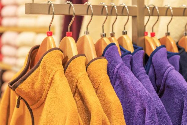 长毛绒多色运动衫衣架在商店的特写，侧视图图片下载