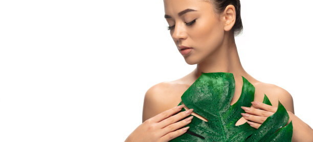 靠近年轻女子的肖像与怪物树叶在白色的背景。化妆品、自然生态护理、皮肤护理。图片下载