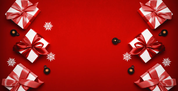 礼品盒猩红色。白色的礼物与猩红丝带，新年球和闪闪发光的灯在圣诞作文在暗红色的背景贺卡。圣诞背景与文字空间。图片下载