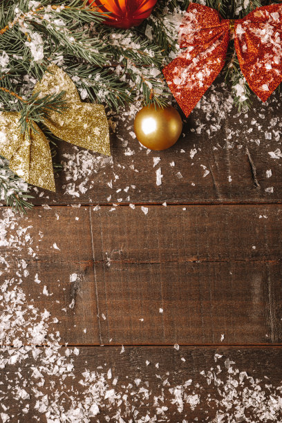 一棵圣诞树的树枝和新年装饰品在雪地上木制的背景垂直照片图片下载