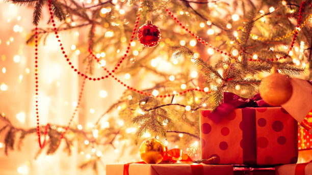 圣诞树下的礼物的大图片让灯光的花环。图片下载