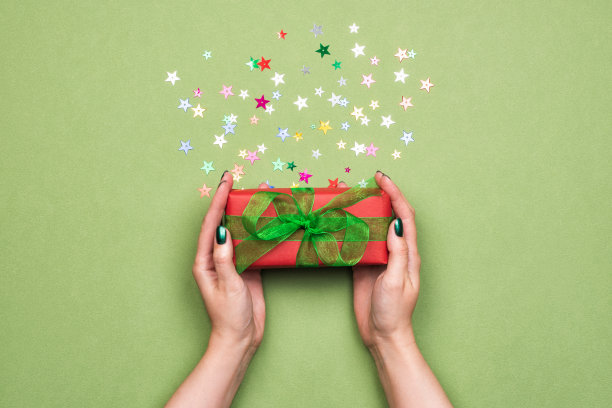 女人手里拿着用红纸包着的礼物图片下载