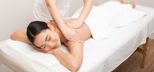 在温泉享受按摩的美女。水疗中心放松按摩图片下载