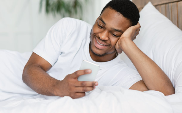 躺在床上发短信的黑人图片下载