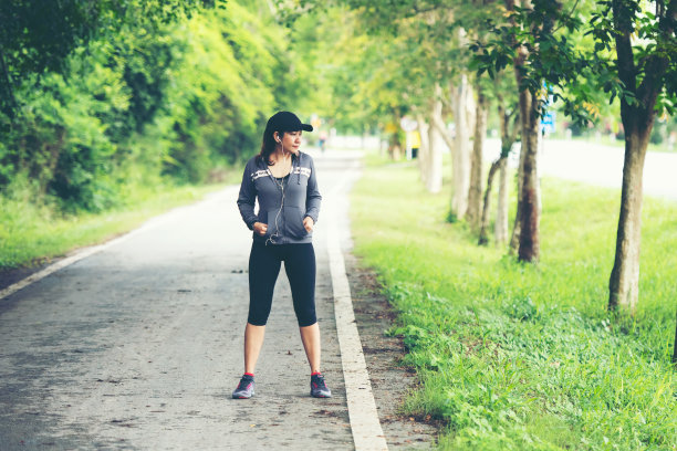 健康的女人慢跑和户外道路锻炼。亚洲跑步者在健身房里锻炼，以自然公园为背景。健康和生活方式概念。图片下载