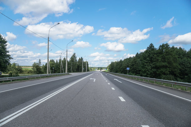 在森林和田野之间的柏油路。一次美丽的驾车旅行。自然资源图片背景图片下载