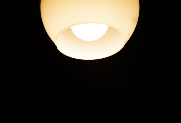 在黑暗的房间里放一盏有灯罩的灯图片下载