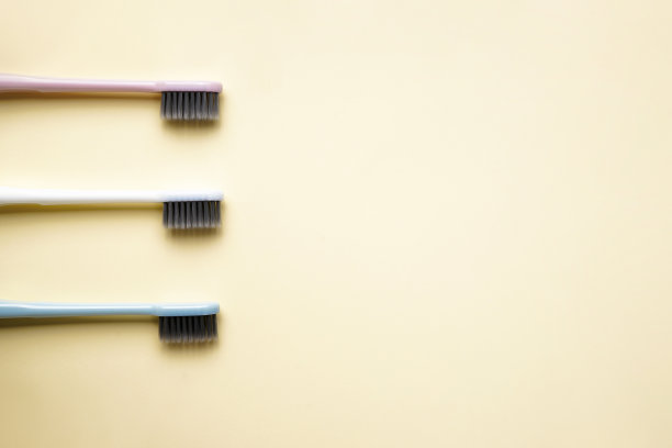 多色牙刷，黄色背景，文字空间，平铺。图片下载