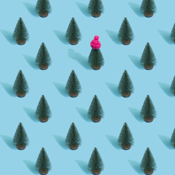 以明亮的淡蓝色为背景的圣诞树做成的新年图案。最小的圣诞节的概念图片下载
