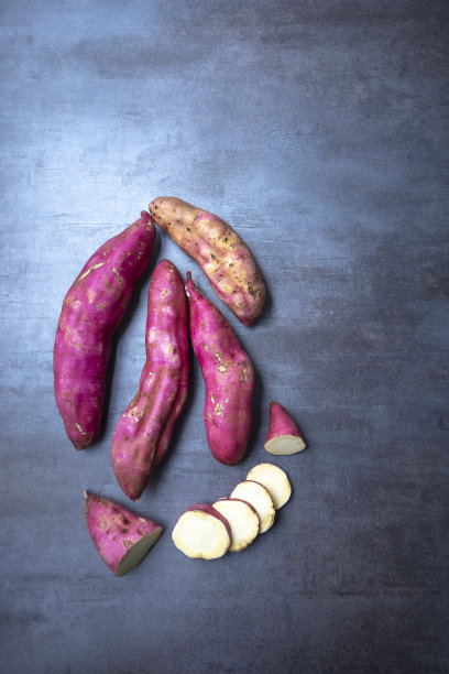 生红薯放在灰色的石头上，从上面看，空间自由。图片下载