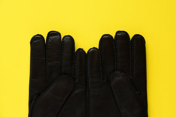 黑色皮手套黄色背景。图片下载