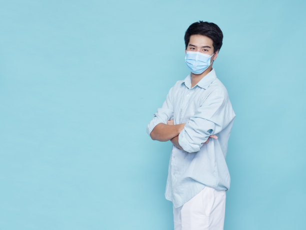 帅气的年轻男子戴着医用口罩，穿着休闲装进行夏季旅行图片下载