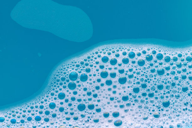 肥皂在蓝色的水中产生泡沫图片下载