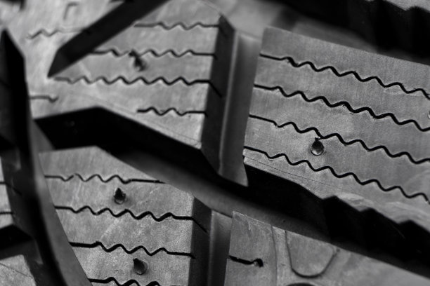 微距拍摄冬季铆钉轮胎。冬季汽车轮胎纹理。轮胎保护关闭。黑色的冬用轮胎轮廓。汽车轮胎图片下载