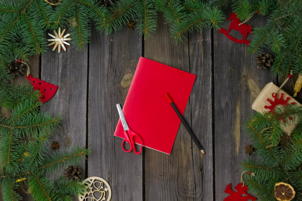 自制圣诞及新年贺卡。在一个有树枝的木桌上，红色的纸手套上有一片白色的雪花。圣诞指示。装饰品。礼物。一步一步来。平的。俯视图图片下载