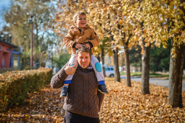 父亲和儿子在秋天公园玩图片下载