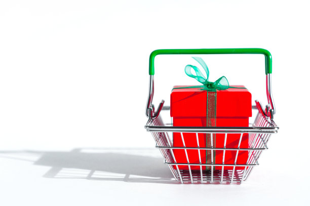 购物篮与红色礼品盒在白色孤立的背景。圣诞节的网上购物。副本的空间。新年和黑色星期五的节日促销和折扣。交易业务。空间的文本。图片下载
