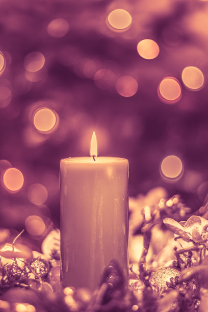 圣诞快乐的概念与绿色燃烧蜡烛照亮圣诞树的背景与散景效果图片下载