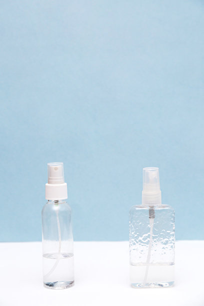 消毒瓶在白色和蓝色背景与拷贝空间。洗手液。卫生保健的概念图片下载