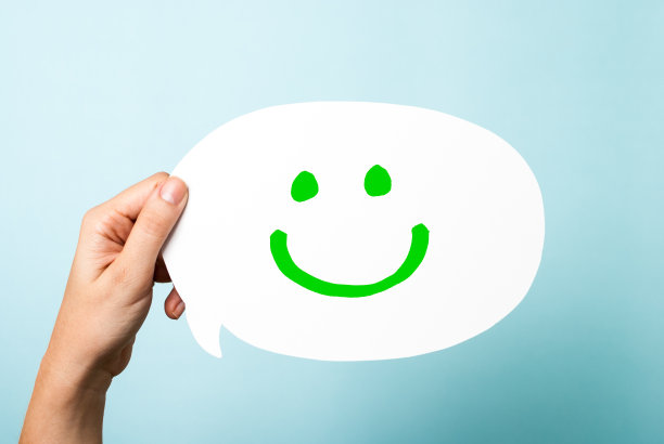 讲话气泡与绘制一个快乐的绿色微笑表情在蓝色的背景图片下载
