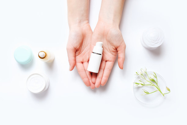 拿着一瓶面霜和化妆品的女人图片下载