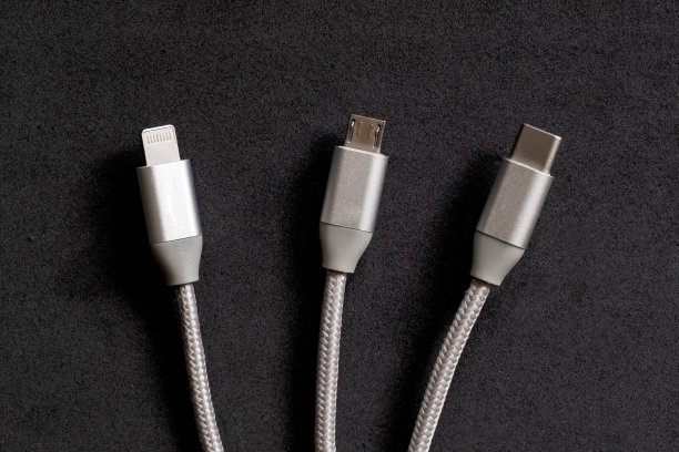 一组智能手机连接器:闪电，微型usb和类型-c电缆在黑暗的背景。图片下载