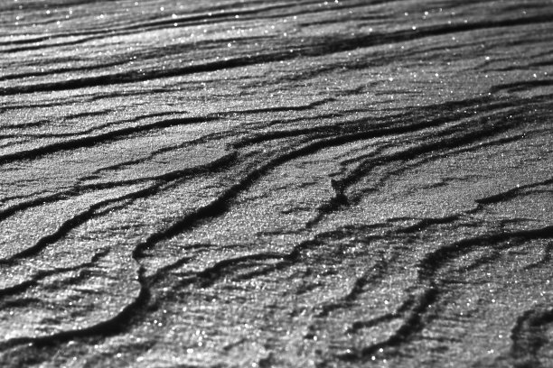 雪白的背景。雪的质地。闪亮的雪与散景和模糊的背景特写。白色的白雪覆盖的领域。雪景微距照片。图片下载