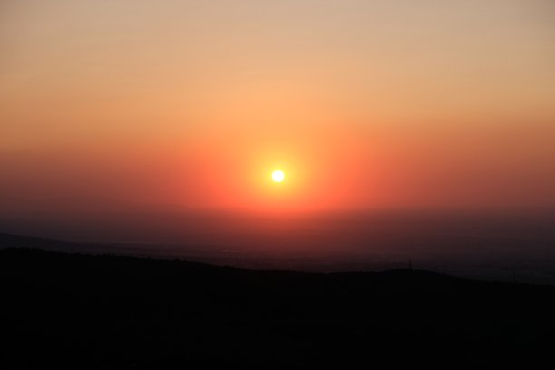 山脚下美丽的日落。橙色的太阳。图片下载