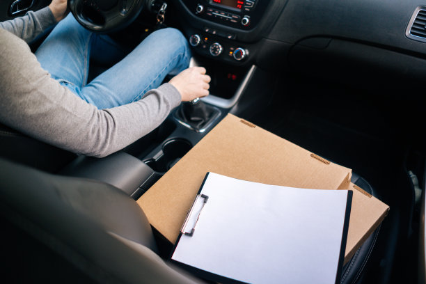 盒子的特写与热披萨和剪贴板在车内的座位。图片下载