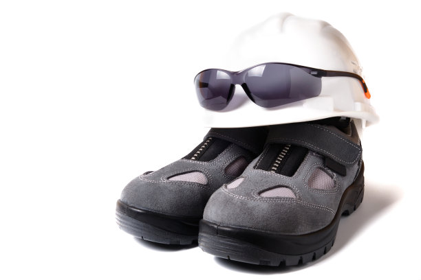 安全帽、防护眼镜和一双新的防护鞋隔离在白色上图片下载