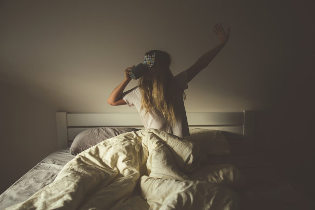 一个美丽的白人女孩躺在床上，背景很亮图片下载