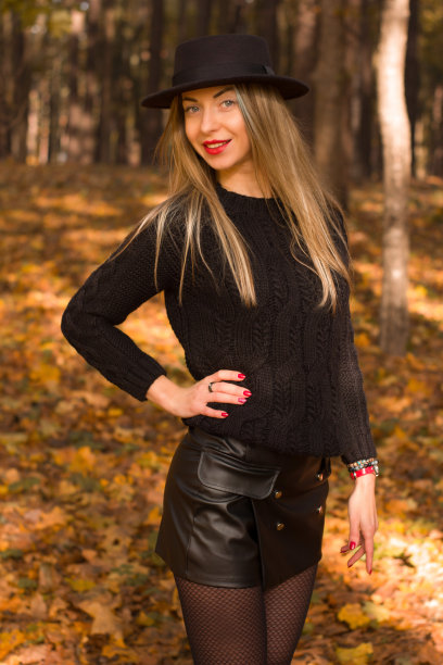 一名年轻女子穿着黑色毛衣、短裤和帽子摆姿势图片下载