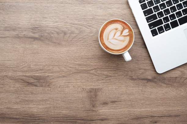 木质办公桌，配有笔记本电脑和一杯拿铁咖啡。顶视图与复制空间，平放。图片下载