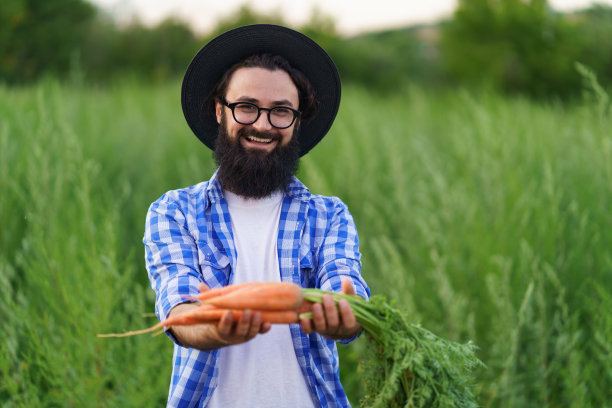 微笑的男人手里拿着一串胡萝卜图片下载