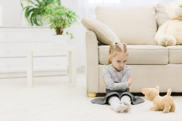 小女孩坐在地毯上的照片。图片下载